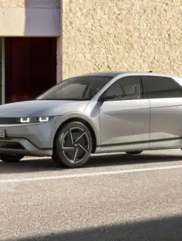 Silberner Hyundai IONIQ 5 steht geparkt vor einer hellen Wand.