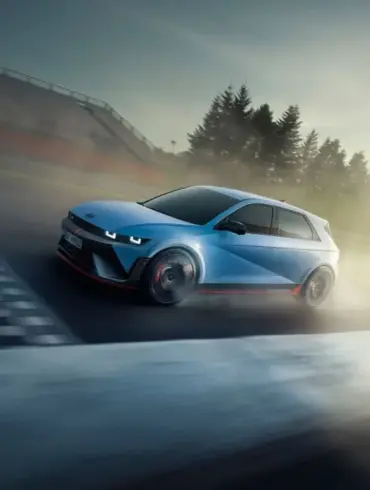 Hyundai IONIQ 5 N in blauer Lackierung driftet dynamisch über eine Rennstrecke bei Sonnenuntergang.