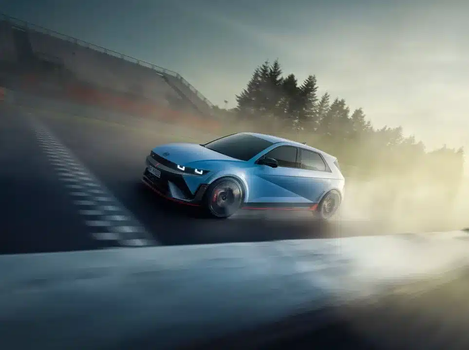 Hyundai IONIQ 5 N in blauer Lackierung driftet dynamisch über eine Rennstrecke bei Sonnenuntergang.