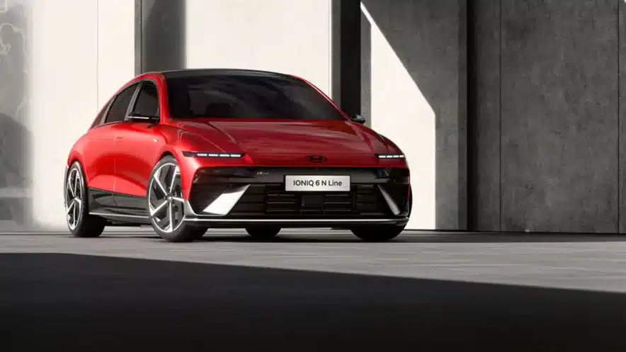 Hyundai IONIQ 6 N Line in leuchtendem Rot, fotografiert von vorn vor einem modernen Gebäude
