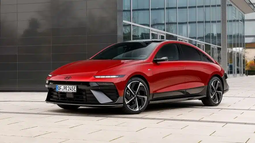 Hyundai IONIQ 6 N Line in roter Lackierung seitlich vor einem modernen Bürogebäude