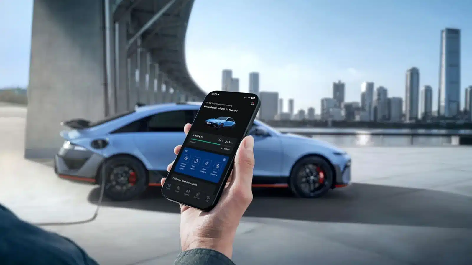 Hyundai IONIQ 6 N beim Laden, im Vordergrund ein Smartphone mit Fahrzeug- und Ladedaten.