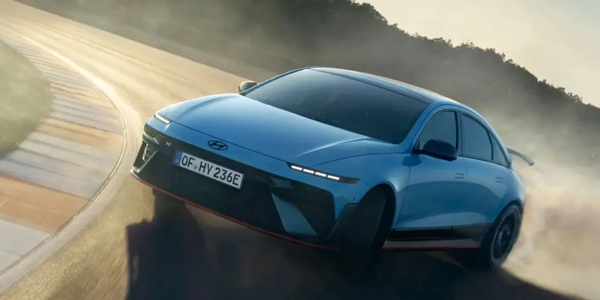 Hyundai IONIQ 6 N fährt dynamisch durch eine Kurve auf einer sonnigen Rennstrecke.