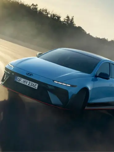 Hyundai IONIQ 6 N fährt dynamisch durch eine Kurve auf einer sonnigen Rennstrecke.