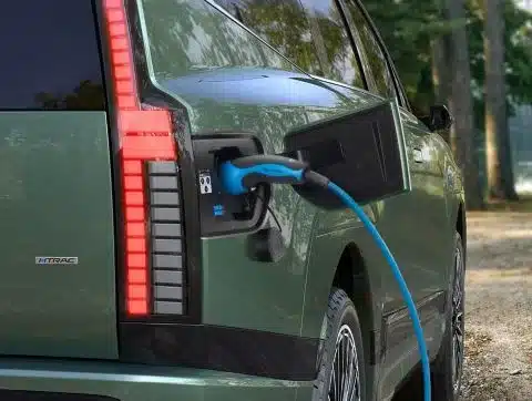 Hyundai IONIQ 9 wird an einer Ladesäule mit blauen Kabel geladen, Nahaufnahme des Hecks.