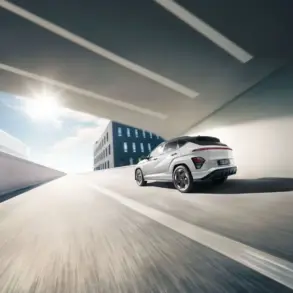 Heckansicht eines weißen Hyundai KONA Elektro, der auf einer städtischen Straße unter einer Brücke fährt.