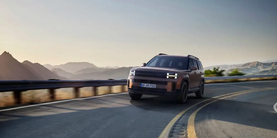 Hyundai SANTA FE Hybrid SUV auf einer kurvigen Bergstraße bei Sonnenaufgang