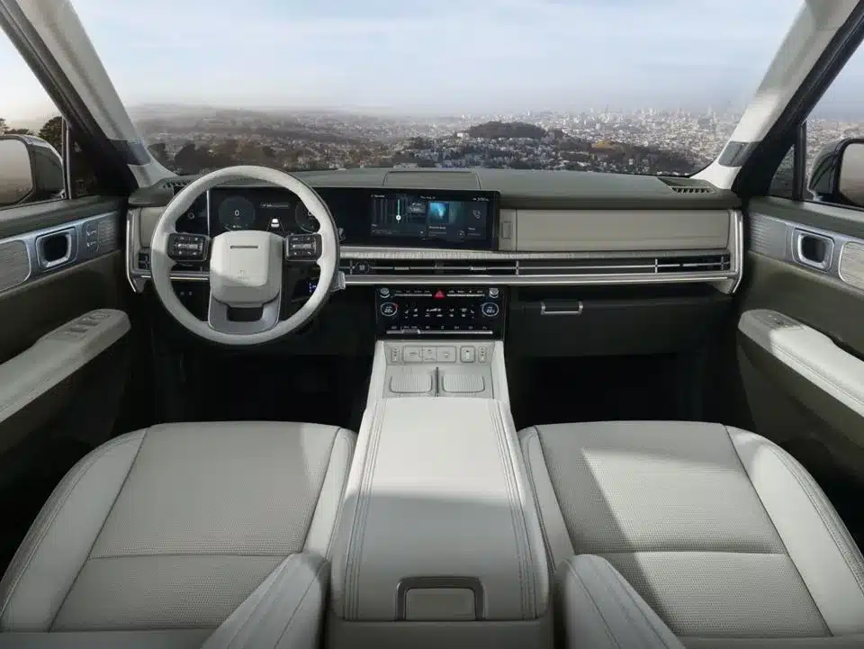 Innenraumansicht des Hyundai SANTA FE Hybrid mit großem Panoramadisplay und hellen Ledersitzen.