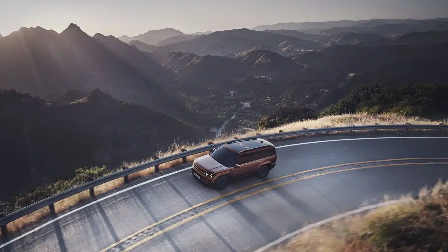 Hyundai Santa Fe Plug-in-Hybrid in braun auf kurviger Bergstraße mit weitem Blick ins Tal.