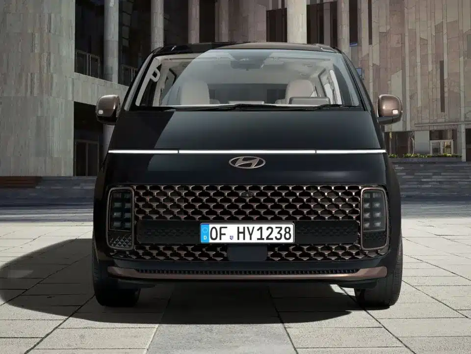 Hyundai STARIA Hybrid von vorne mit markanter Lichtsignatur und großem Kühlergrill.