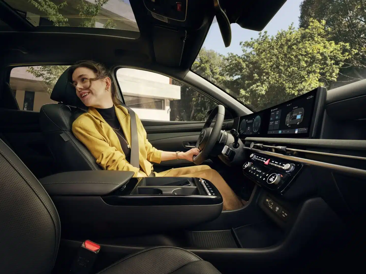Innenraum des Hyundai Tucson Plug-in-Hybrid mit moderner Armatur, großen Displays und einer Fahrerin am Steuer
