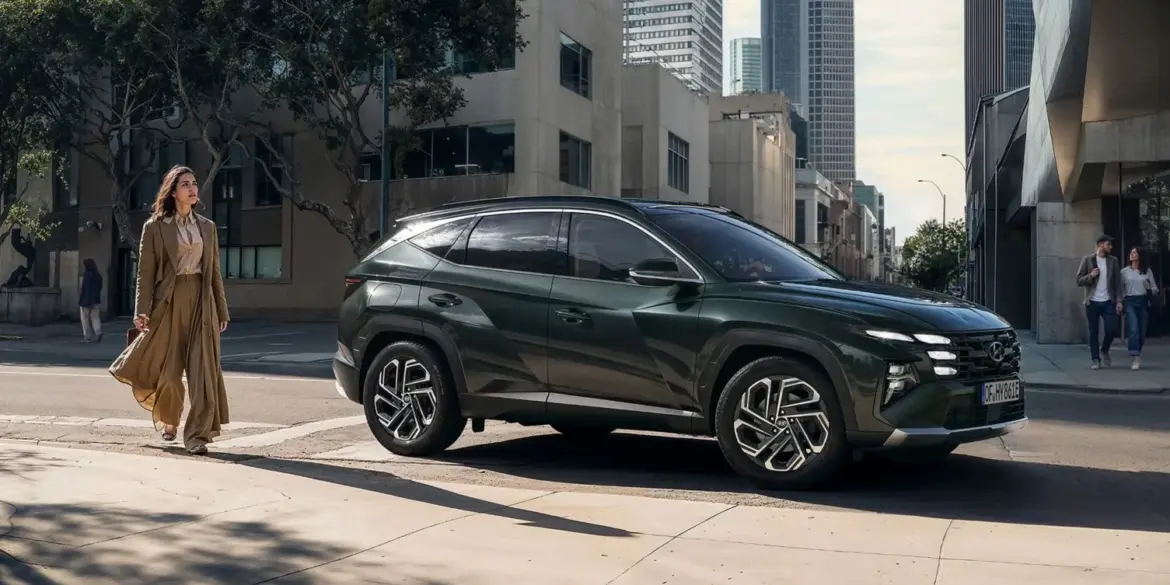 Seitliche Ansicht eines Hyundai Tucson in dunkelgrün, geparkt am Straßenrand einer modernen Stadt.