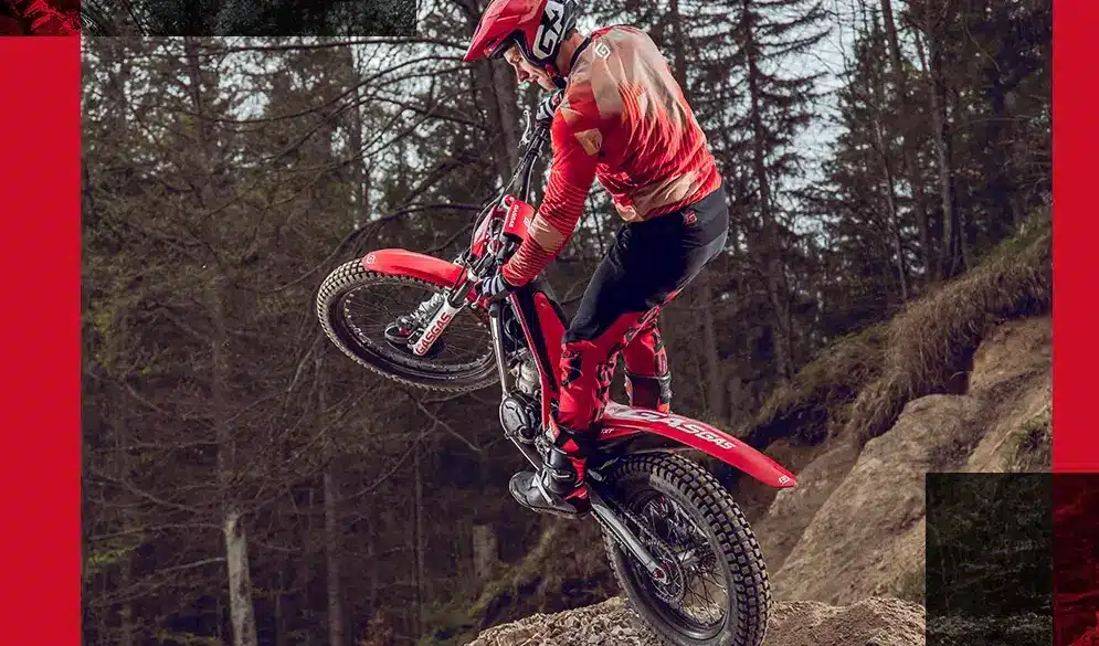 Trialfahrer auf einer GASGAS TXT RACING 250 2025 beim Überwinden eines Hindernisses im Gelände.