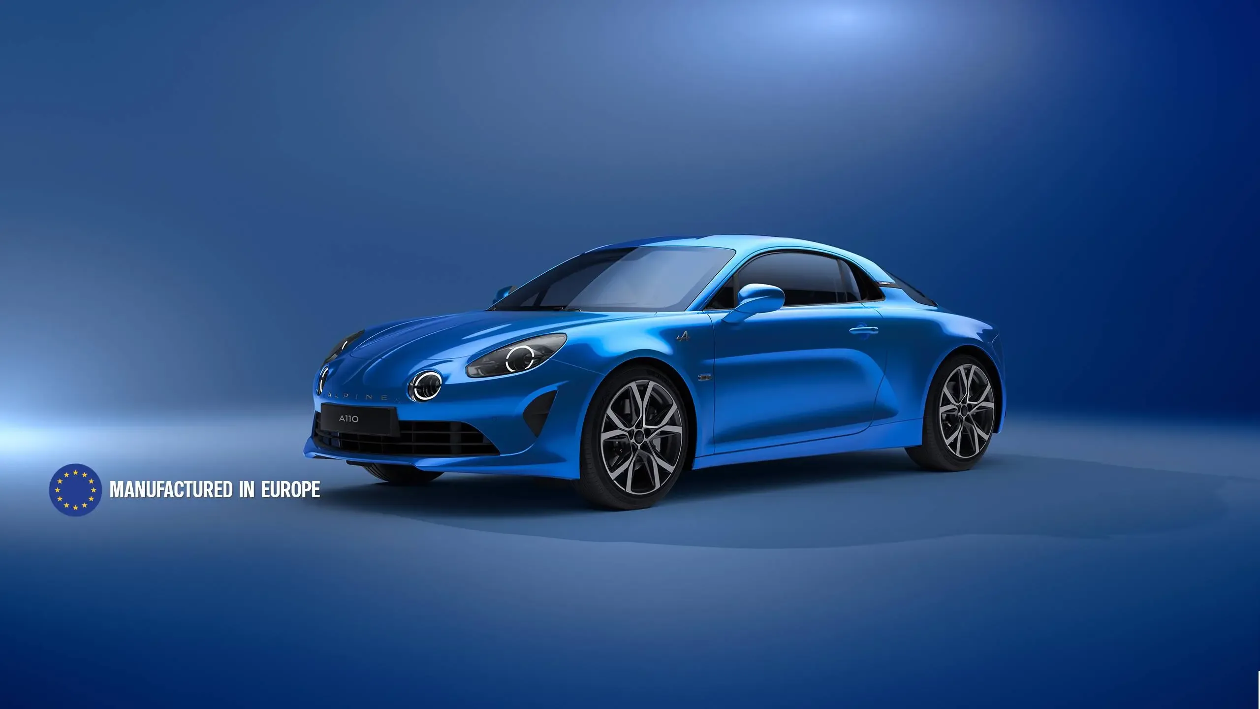 Blauer Alpine A110 Sportwagen vor blauem Hintergrund, Seitenansicht.