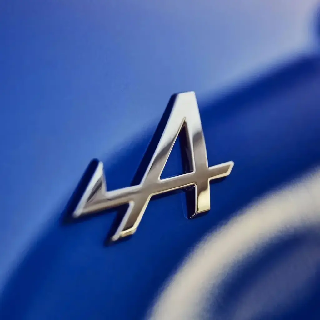 Emblem des Alpine A110 auf blauer Fahrzeugoberfläche