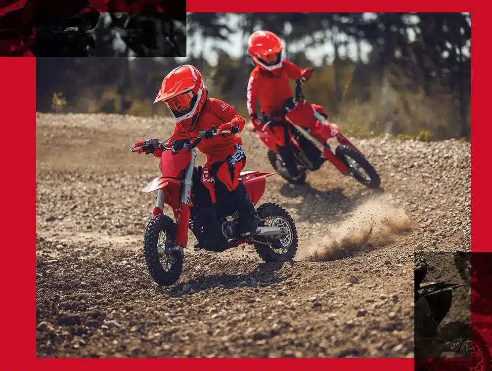 Zwei Kinder fahren die rote GASGAS MC-E 3 2024 auf einer Offroad-Strecke.