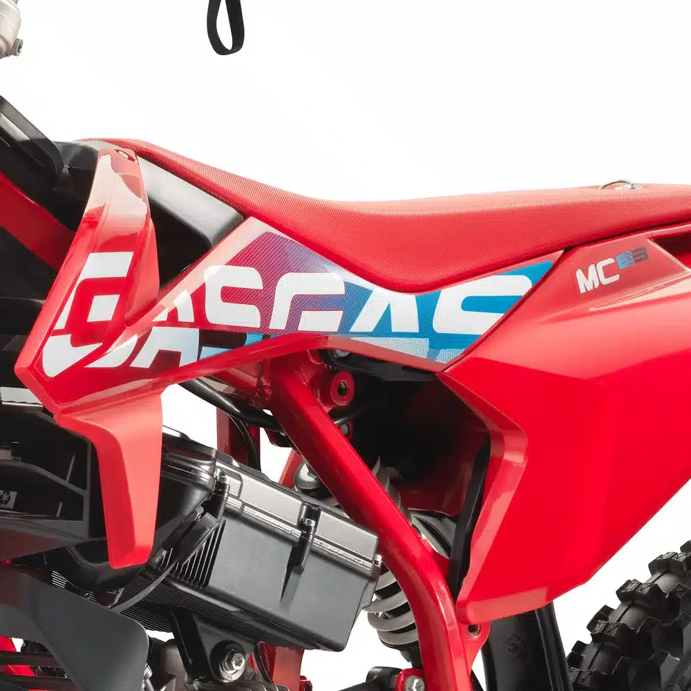 Seitliches Detailbild des GASGAS MC-E 3 2024 Elektromotorrads mit rotem Rahmen und sichtbarem Elektromotor.