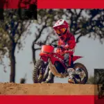 Kind auf GASGAS MC-E 2 Elektromotorrad mit roter Schutzkleidung im Gelände