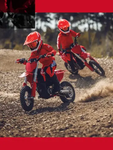 Zwei Kinder fahren auf einer GASGAS MC-E 3 Elektro-Motocross auf einer Offroad-Strecke