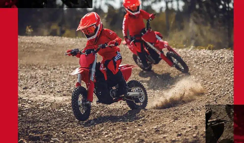 Zwei Kinder fahren auf einer GASGAS MC-E 3 Elektro-Motocross auf einer Offroad-Strecke