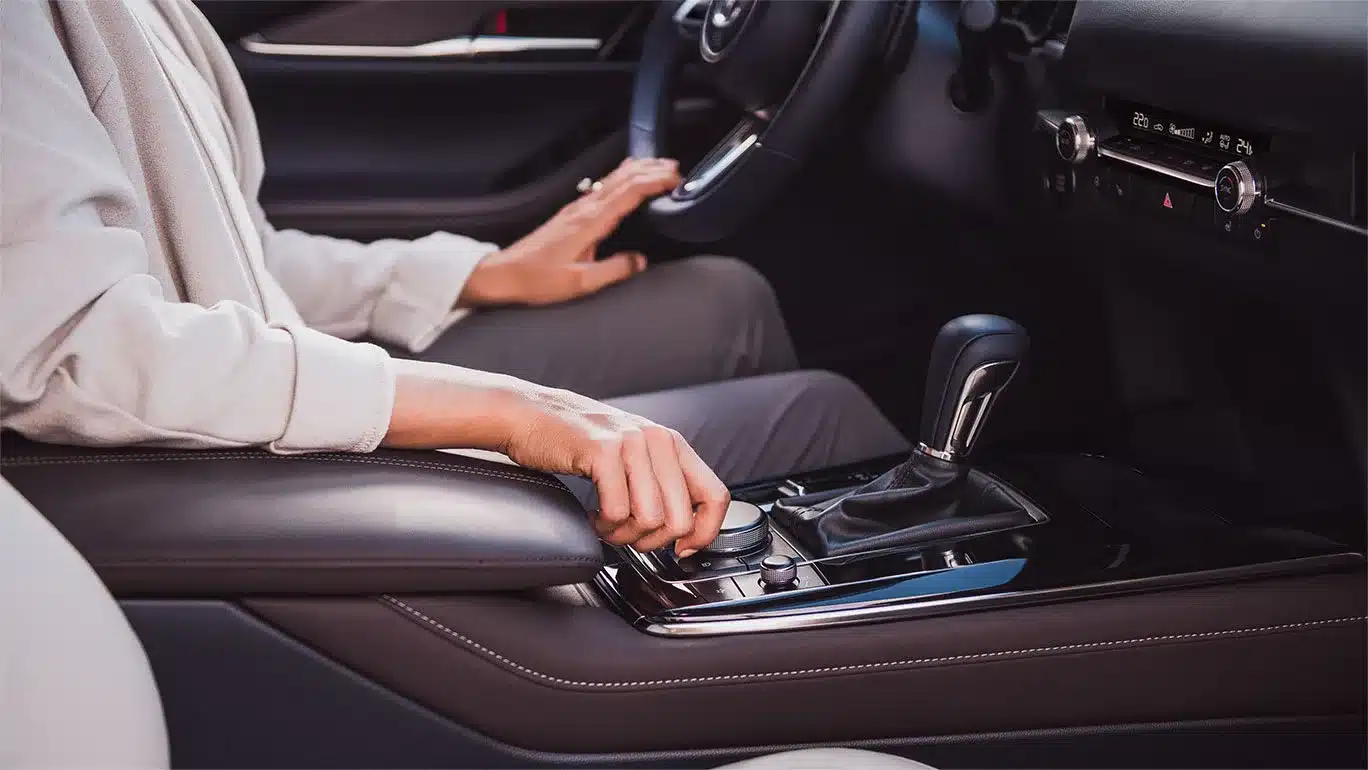 Detailansicht des Innenraums eines Mazda CX-30 mit Fokus auf Mittelkonsole, Automatikschalthebel und Drehregler.