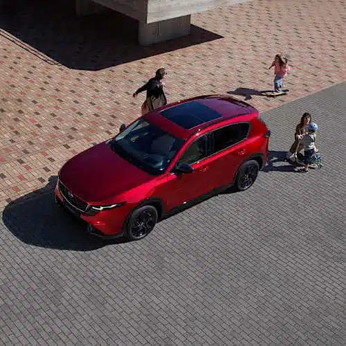 Mazda CX-5 dritte Generation, rotes SUV seitlich von oben, Familie steigt ein