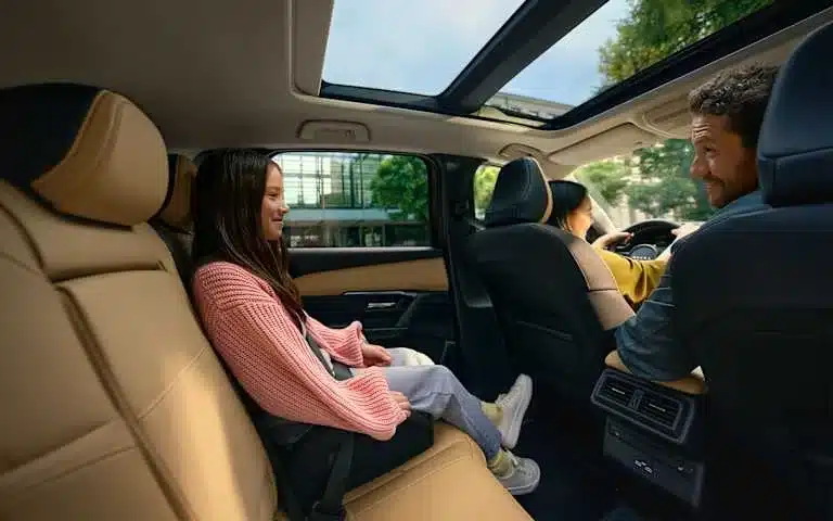 Kind sitzt entspannt auf der Rückbank eines Mazda CX-5 mit Panoramadach, moderner Innenraum