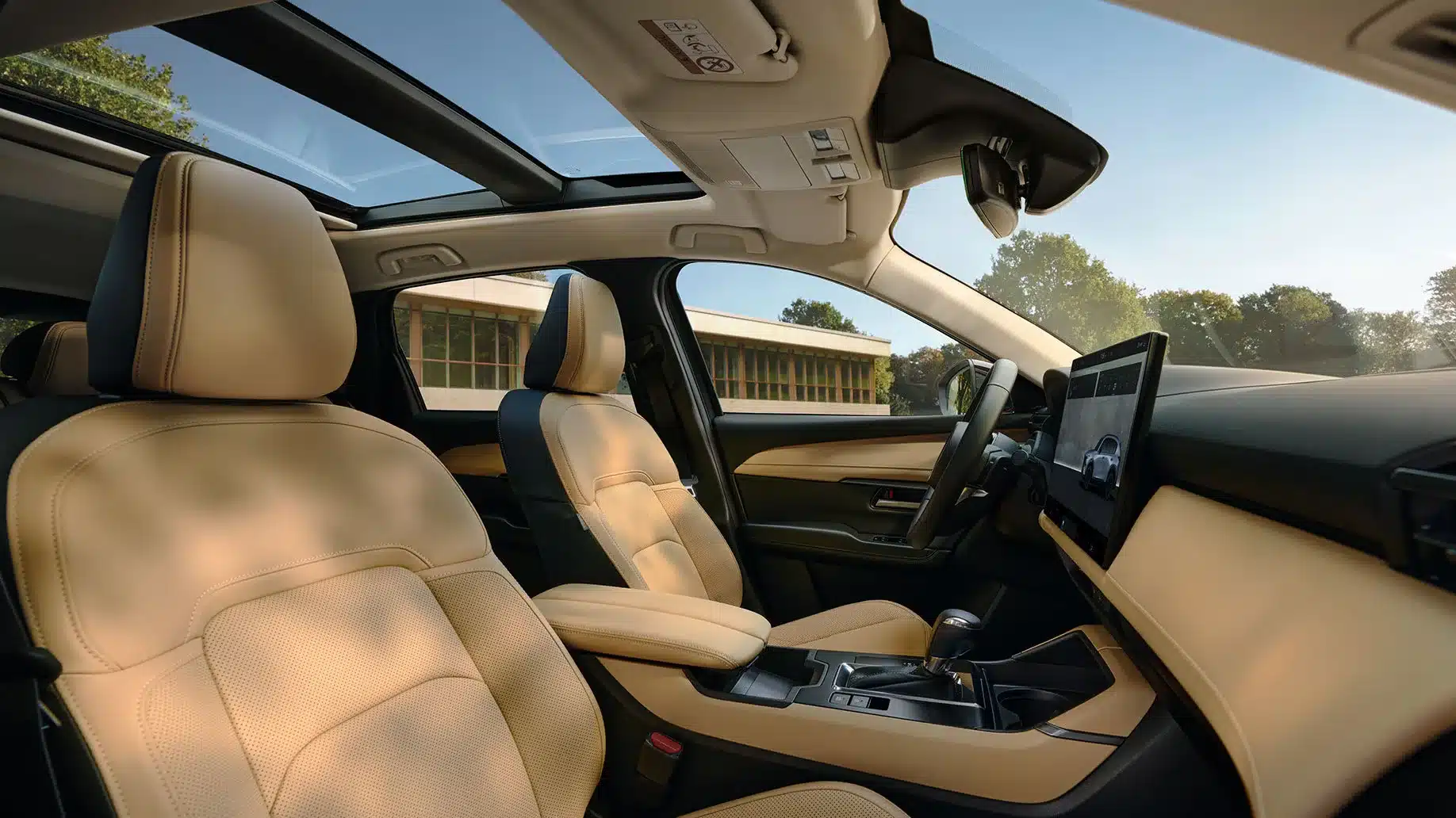 Innenraum vom neuen Mazda CX-5, vordere Sitze in beige, Panorama-Glasdach und großes Touchdisplay.