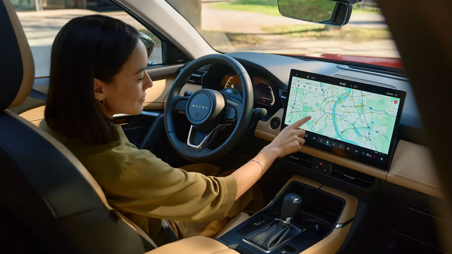 Fahrerin bedient das große Touchdisplay im Cockpit des neuen Mazda CX-5