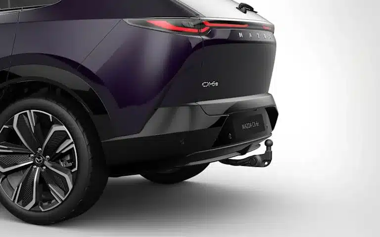 Mazda CX-6e Heckansicht mit Anhängerkupplung in violetter Metallic-Lackierung.