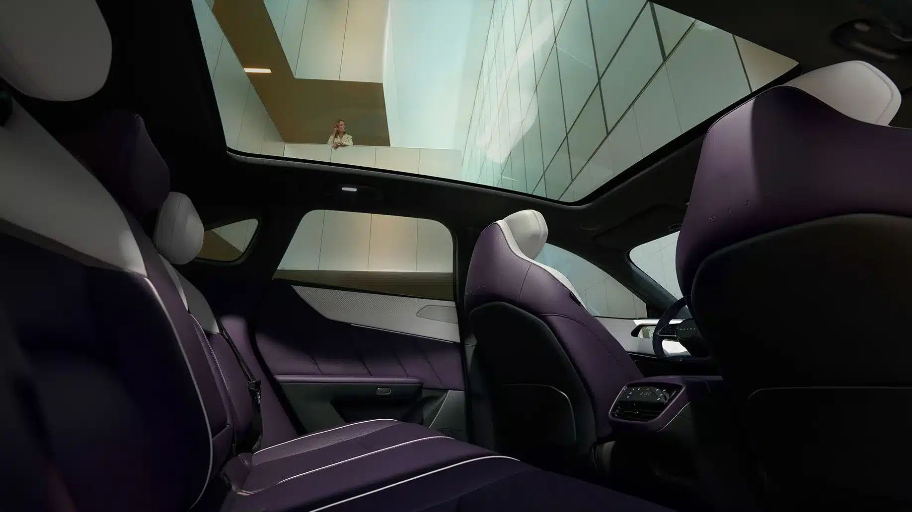 Blick in den Innenraum des Mazda CX-6e mit Panoramadach und violetten Sitzen