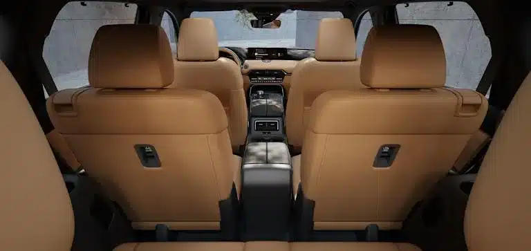 Innenraum des Mazda CX-80 mit sechs Einzelsitzen in braunem Leder, Blick von hinten nach vorn.