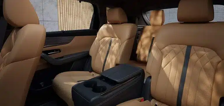 Innenraum des Mazda CX-80 mit luxuriösen Einzelsitzen und Mittelarmlehne in der zweiten Sitzreihe, Nappaleder und Holzdekor.