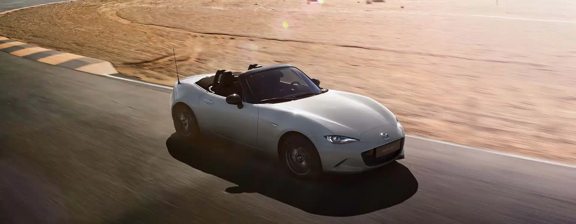 Mazda MX-5 2024 in Aero Grey Metallic als Roadster auf einer Rennstrecke bei Sonnenschein