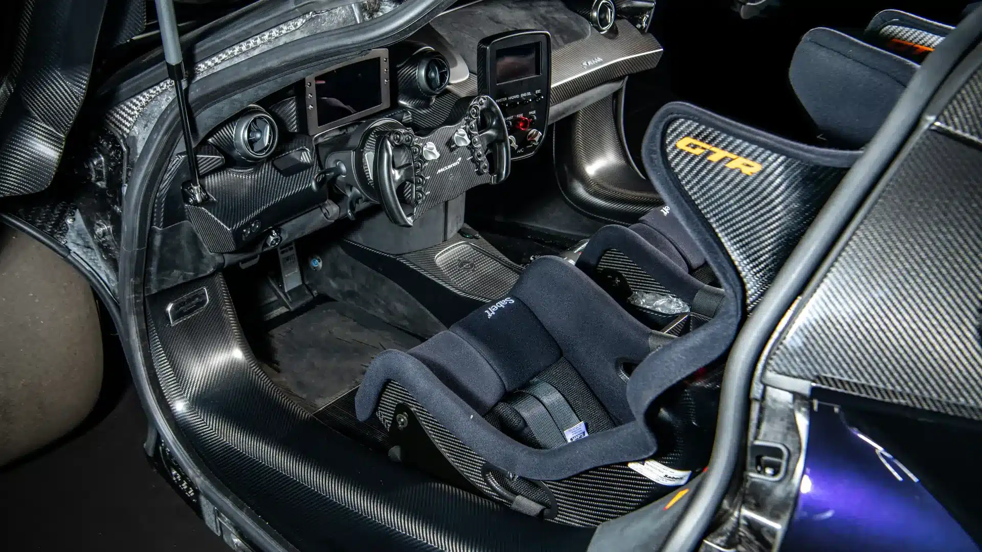 Nahaufnahme vom Cockpit des McLaren Senna GTR mit Carbonbauteilen, Schalensitz und Rennlenkrad.