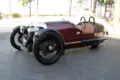 Morgan Three-Wheeler von 2012, burgundfarben, mit offenem V2-Motor und zwei Vorderrädern, Seitenansicht