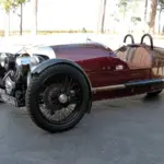Morgan Three-Wheeler von 2012, burgundfarben, mit offenem V2-Motor und zwei Vorderrädern, Seitenansicht