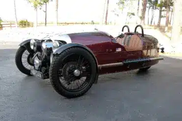 Morgan Three-Wheeler von 2012, burgundfarben, mit offenem V2-Motor und zwei Vorderrädern, Seitenansicht