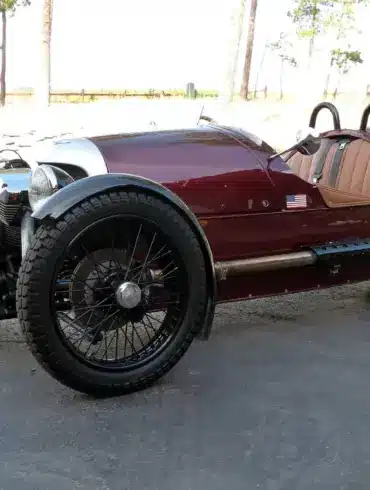 Morgan Three-Wheeler von 2012, burgundfarben, mit offenem V2-Motor und zwei Vorderrädern, Seitenansicht