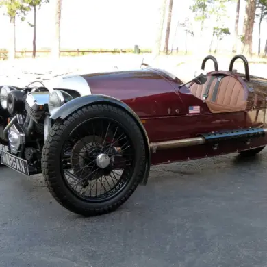 Morgan Three-Wheeler von 2012, burgundfarben, mit offenem V2-Motor und zwei Vorderrädern, Seitenansicht