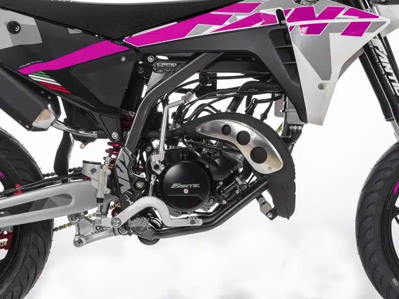 Nahaufnahme des Motors und Rahmens der Moto Motard XM 50 Performance 2025 mit markanten Pink- und Schwarzakzenten.