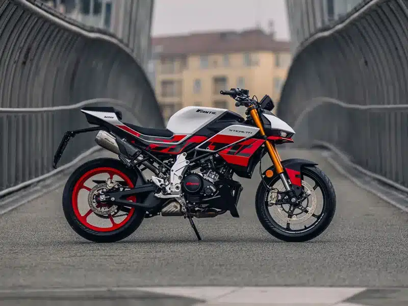 Seitenansicht der Fantic Stealth 125 Racing White auf einer modernen Brücke.