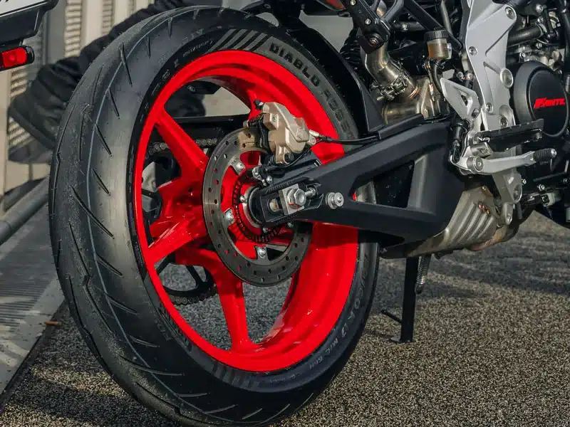 Nahaufnahme des Hinterrades mit Pirelli Diablo Rosso IV Reifen, Scheibenbremse und Aluminium-Schwinge einer Stealth 125 Racing White