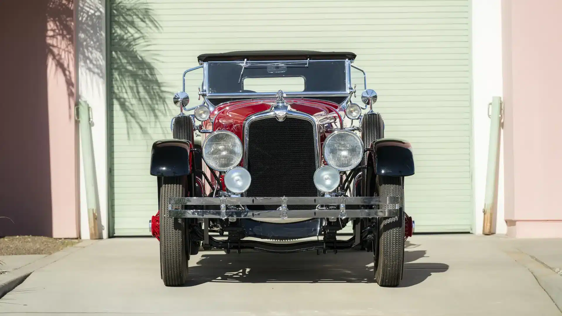 Frontansicht des Stutz Model BB Custom Black Hawk Two-Passenger Speedster von 1928 mit auffälligen Chromdetails und roten sowie schwarzen Karosserieteilen.