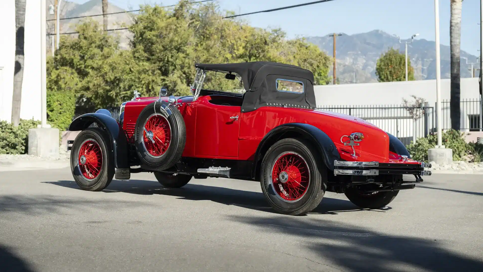 Seitenansicht eines restaurierten Stutz Model BB Black Hawk Two-Passenger Speedster von 1928, rot mit schwarzen Kotflügeln, aufgenommen im Freien