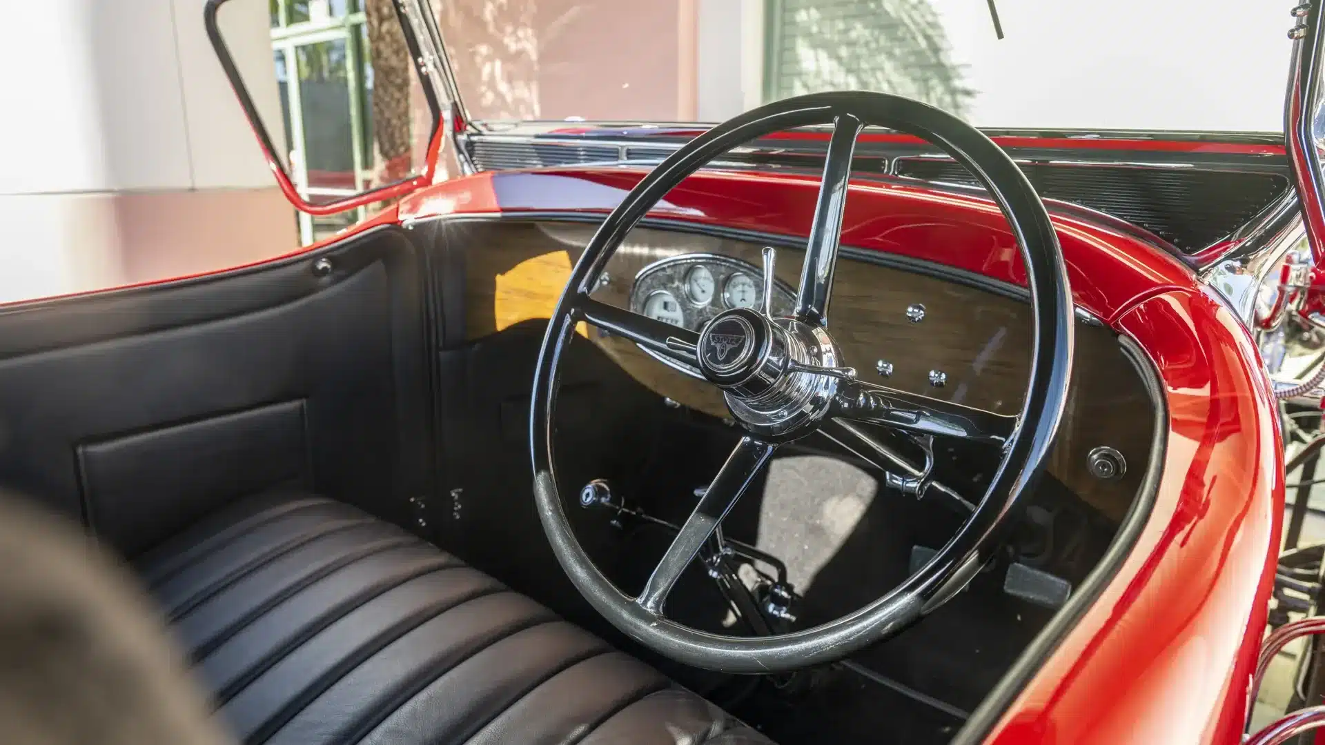 Historischer Innenraum eines Stutz Model BB Custom Black Hawk Two-Passenger Speedster von 1928 mit schwarzem Lenkrad und Armaturenbrett.