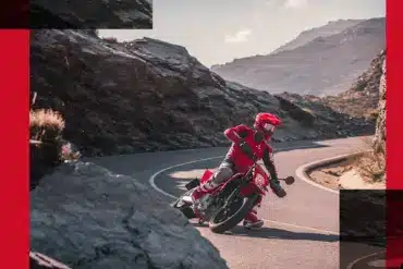 Motorradfahrer auf roter GasGas SM 700 2024 beim sportlichen Fahren auf einer kurvigen Bergstraße.