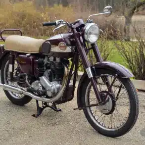Ariel Red Hunter 497-ccm Einzylinder-Motorrad Baujahr 1955 mit patinierter Lackierung und beigem Sitz, stehend auf einem Hofweg