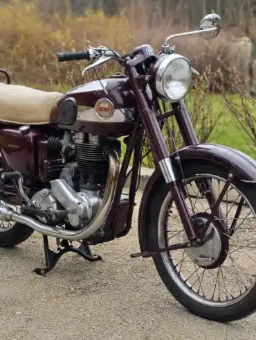 Ariel Red Hunter 497-ccm Einzylinder-Motorrad Baujahr 1955 mit patinierter Lackierung und beigem Sitz, stehend auf einem Hofweg