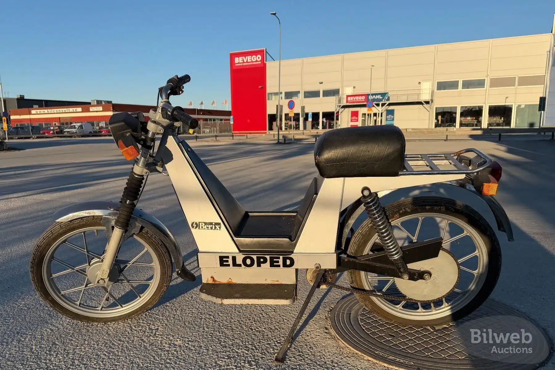 Seitenansicht einer Berix Eloped, einem klassischen schwedischen Elektromoped aus den 1980er-Jahren, aufgenommen auf einem Parkplatz bei Tageslicht.